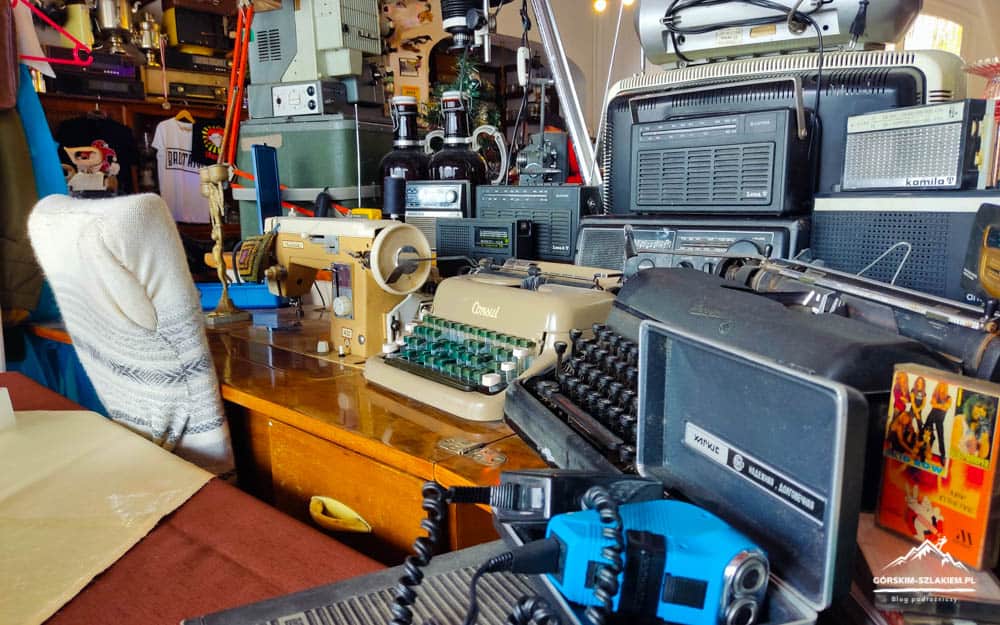 Zbiór sprzętu i narzędzi na tle warsztatu górskiego szlaku.