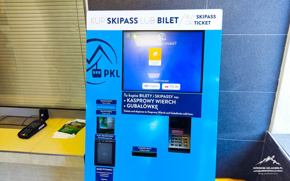 Blue PKL ticket vending machine with touchscreen, keypad and payment slot beside a yellow counter area