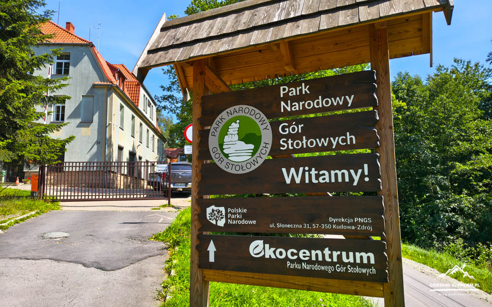 Wooden trail sign for Park Narodowy Gór Stołowych with 'Witamy!' and directions in Polish (Polish national park welcome sign).